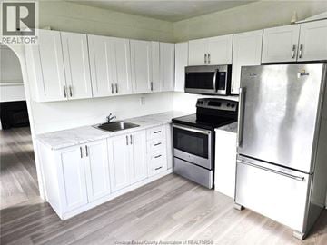 Windsor apartment for rent - A kitchen with white cabinets and a stainless steel refrigerator.