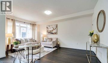 Stoney Creek townhouse for rent - A well-lit living room with a white sofa and a coffee table.