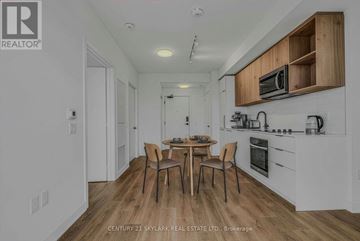 Toronto (Dovercourt-Wallace Emerson-Junction) condo for rent - A kitchen with a table and chairs in the middle of the room.
