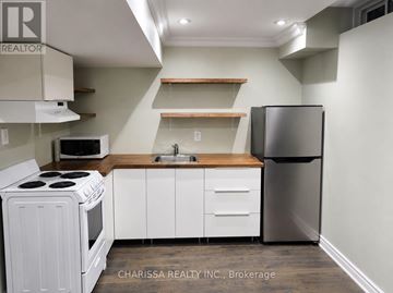 Hamilton (Waterdown) apartment for rent - A kitchen with white appliances and wooden shelves.