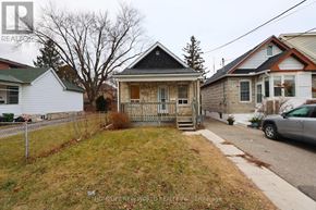 Toronto (Rockcliffe-Smythe) apartment for rent - A white house with a black roof is in front of a tree and a car.
