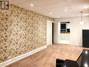 Toronto (Rockcliffe-Smythe) apartment for rent - A room with floral wallpaper and a wooden floor.