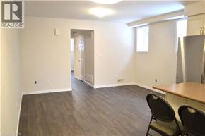Kitchener townhouse for rent - A room with a wooden floor and a refrigerator in the corner.