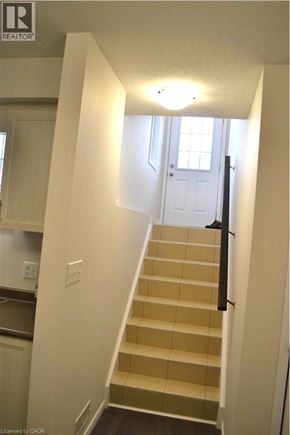 Kitchener townhouse for rent - A staircase with a light on the wall above it.