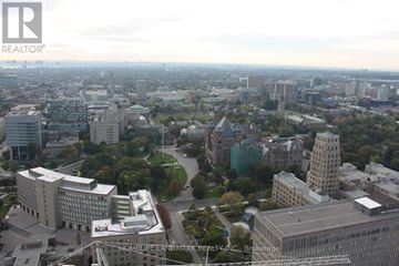 Toronto (Bay Street Corridor) condo for rent - A cityscape with buildings and a road in the foreground.