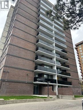 Toronto (Woburn) condo for rent - A tall brick building with balconies on the upper floors.