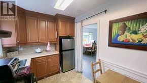 Toronto (Wexford-Maryvale) apartment for rent - A kitchen with wooden cabinets and a painting on the wall.