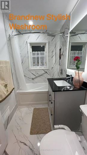 Toronto (Wexford-Maryvale) apartment for rent - A white toilet in a bathroom with a marble wall.
