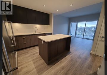 Vancouver apartment for rent - A modern kitchen with dark wood cabinets and a white countertop.