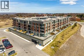 Hamilton condo for rent - A large apartment complex with a parking lot in front.