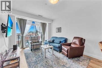 Hamilton condo for rent - A living room with a brown leather chair and a blue sofa.