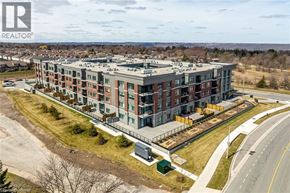 Hamilton condo for rent - A large apartment complex with a parking lot in front.