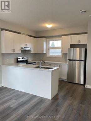 Niagara Falls (Morrison) townhouse for rent - A kitchen with white cabinets and a stainless steel refrigerator.