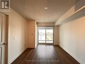 Pickering (Bay Ridges) condo for rent - A room with a door and a window with a view of a parking lot.