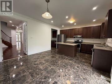 Oshawa (Taunton) apartment for rent - A kitchen with brown cabinets and a marble floor.