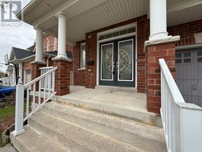 Oshawa (Taunton) apartment for rent - A house with a front porch and a staircase leading to it.