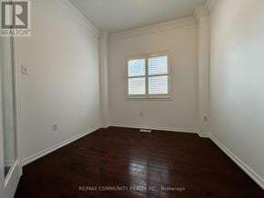 Oshawa (Taunton) apartment for rent - A room with a window and wooden flooring.