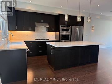 Toronto (Willowridge-Martingrove-Richview) townhouse for rent - A modern kitchen with black cabinets and a white island.