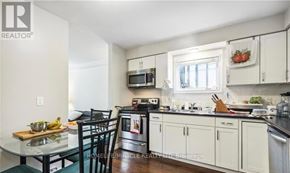 Kitchener triplex for rent - A kitchen with white cabinets and a black countertop.