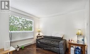 Kitchener triplex for rent - A bedroom with a bed, nightstand, and window with blinds.