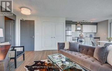 Toronto (Waterfront Communities) condo for rent - A living room with a brown couch and a glass coffee table.