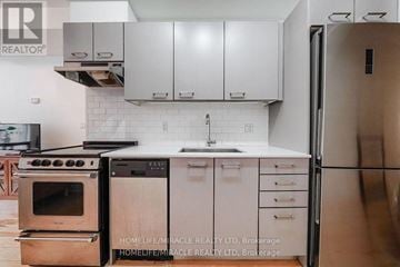 Toronto (Greenwood-Coxwell) townhouse for rent - A kitchen with a stove, sink, and refrigerator.