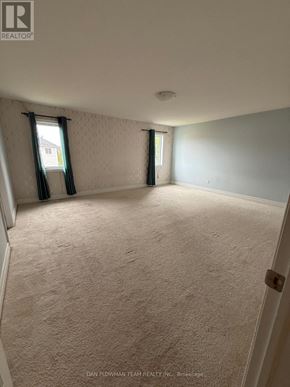 Oshawa (Samac) apartment for rent - A room with a carpeted floor and a window with curtains.