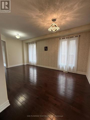 Oshawa (Samac) apartment for rent - A room with wooden floors and a chandelier.
