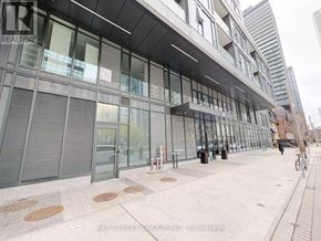 Toronto (Church-Yonge Corridor) condo for rent - A modern building with glass windows and a bicycle parked in front.