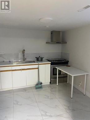 Toronto (Agincourt North) apartment for rent - A kitchen with white cabinets and a white table.