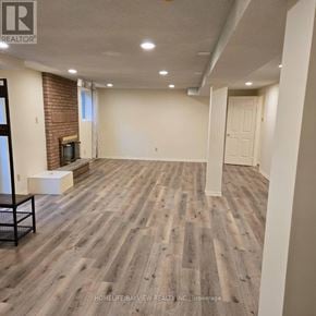 Markham (Thornlea) apartment for rent - A spacious living room with wooden flooring and a brick fireplace.