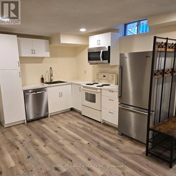 Markham (Thornlea) apartment for rent - A kitchen with white cabinets and a wooden floor.