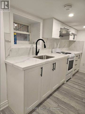 Toronto (Palmerston-Little Italy) apartment for rent - A white kitchen with a sink and a window.