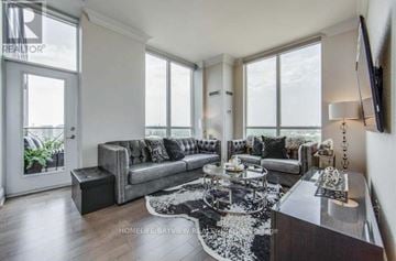 Toronto (Banbury-Don Mills) condo for rent - A living room with a grey couch and a black and white rug.