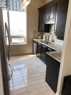 Toronto (Banbury-Don Mills) condo for rent - A kitchen with a refrigerator, sink, and cabinets.