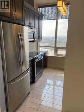 Toronto (Banbury-Don Mills) condo for rent - A kitchen with a stainless steel refrigerator and black cabinets.