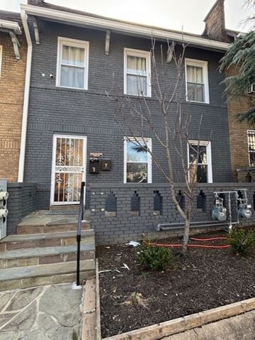 Washington apartment for rent - A grey house with a tree in front.