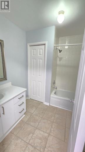 Innisfil multi-family for rent - A white bathroom with a door and a shower.