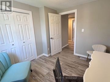St. Catharines (Lakeport) apartment for rent - A living room with a blue couch and a white door.