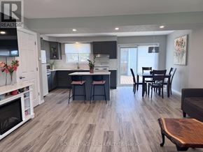 St. Catharines (Lakeport) apartment for rent - A modern kitchen with a wooden floor and a dining table with chairs.