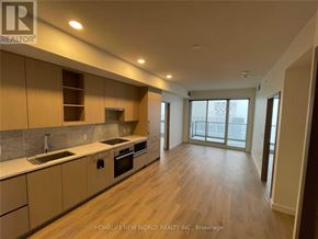 Toronto (Bayview Village) condo for rent - A kitchen with wooden floors and beige cabinets.