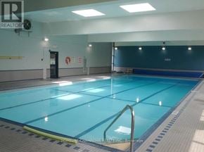 Toronto (Pleasant View) condo for rent - A large indoor swimming pool with a blue bottom and white walls.