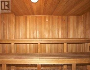 Toronto (Pleasant View) condo for rent - A wooden sauna with a bench and a light on the ceiling.