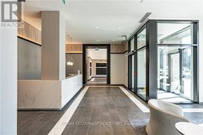 Hamilton (Beasley) condo for rent - A hallway with a marble floor and a glass wall on the right side.