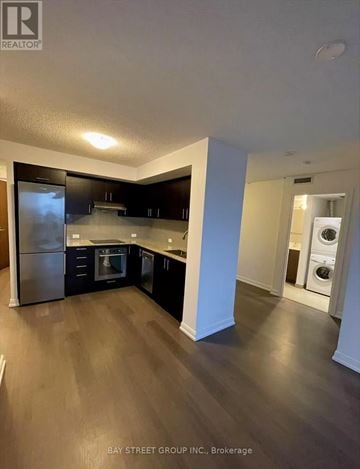 Toronto (Agincourt South-Malvern West) condo for rent - A kitchen with dark wood floors and stainless steel appliances.