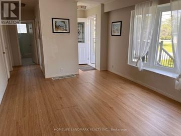 East Gwillimbury (Holland Landing) apartment for rent - A room with wooden floors and white walls, with a window on the right side.