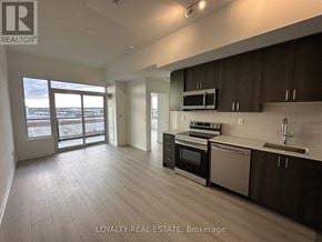Pickering (Bay Ridges) condo for rent - A spacious kitchen with dark brown cabinets and a white countertop.