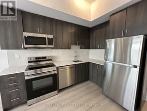 Pickering (Bay Ridges) condo for rent - A modern kitchen with stainless steel appliances and wooden cabinets.