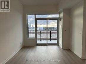 Pickering (Bay Ridges) condo for rent - A room with a large window overlooking a cityscape.