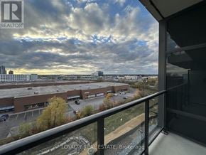 Pickering (Bay Ridges) condo for rent - A view from a balcony overlooking a parking lot and buildings.